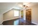 Bedroom featuring two wood doors, dormer window, ceiling fan, and wood floors at 250 Hester Rd, Carrollton, GA 30116