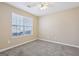 Bedroom features include neutral walls, a ceiling fan, carpet, and a large window at 75 Bretts Bnd, Sharpsburg, GA 30277