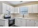 Kitchen features white cabinetry, stainless appliances, neutral countertops and a tile backsplash at 75 Bretts Bnd, Sharpsburg, GA 30277