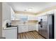 Bright kitchen with white cabinets, stainless steel appliances, and wood-look floors at 75 Bretts Bnd, Sharpsburg, GA 30277