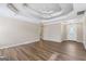Open concept living room with tray ceilings, neutral paint, wood floors and a front door view at 75 Bretts Bnd, Sharpsburg, GA 30277