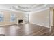 Spacious living room features a tray ceiling, fireplace, and wood-look floors at 75 Bretts Bnd, Sharpsburg, GA 30277