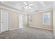 This main bedroom features a ceiling fan, tray ceilings, neutral walls, and carpet at 75 Bretts Bnd, Sharpsburg, GA 30277