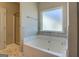 Bright bathroom with a tiled tub/shower combo, frosted window, and tile flooring at 509 Cowpens Rd, Social Circle, GA 30025