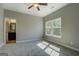 Spacious bedroom with carpet, a ceiling fan, ensuite bathroom and natural light from the window at 509 Cowpens Rd, Social Circle, GA 30025