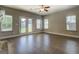 Living room with wood flooring, double doors, and three windows at 509 Cowpens Rd, Social Circle, GA 30025