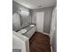Bathroom featuring dual sinks, ample counter space, and wood-look flooring at 530 Shadowmoore Dr, Riverdale, GA 30274