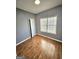 Empty bedroom with hardwood floors, neutral paint, and a window providing natural light at 530 Shadowmoore Dr, Riverdale, GA 30274