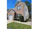 A view of the home's exterior that highlights the brick facade, and well-maintained landscaping at 530 Shadowmoore Dr, Riverdale, GA 30274
