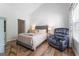 Cozy bedroom with a gray upholstered bed, natural light, and comfortable armchair at 949 Pike Forest Dr, Lawrenceville, GA 30045