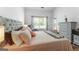 Bright bedroom with a tufted headboard bed, plush pillows, and natural light streaming in at 949 Pike Forest Dr, Lawrenceville, GA 30045
