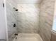 Bathroom featuring tiled shower with updated fixtures and a bright window at 2566 Nw Santa Barbara Dr, Atlanta, GA 30318