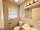 A quaint bathroom offers a sink, mirror, and toilet, bathed in soft light at 3566 Fairlane Nw Dr, Atlanta, GA 30331