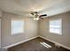 Cozy bedroom with neutral walls, plush carpeting, and natural light from the two windows at 3566 Fairlane Nw Dr, Atlanta, GA 30331