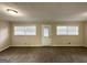 Spacious living room with carpeted floors, featuring natural light from windows and access to the outside at 518 Hammett Dr, Decatur, GA 30032