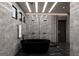 Modern bathroom featuring a black freestanding tub, glass enclosed shower, and elegant lighting fixtures at 2704 Antioch Ne St, Conyers, GA 30013