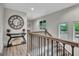 Hallway landing with elegant wood stair rail, striking wall clock, and wood-style floors at 4 & 5 Northlake Cir, Peachtree City, GA 30269