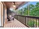 Cozy screened-in porch with wood flooring, wicker chairs, and views of lush greenery at 4 & 5 Northlake Cir, Peachtree City, GA 30269