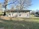 Backyard view of a brick home with mature trees and a well-maintained lawn at 4267 Lamar St, Decatur, GA 30035