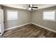 Bedroom with wood-look flooring, ceiling fan, and two large windows at 2676 Stone Rd, East Point, GA 30344