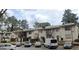 Apartment building featuring traditional architecture, outdoor parking, and mature trees at 3834 Kensingwood Trce, Decatur, GA 30032