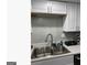 Kitchen featuring stainless steel sink, white cabinets, and a modern backsplash at 3834 Kensingwood Trce, Decatur, GA 30032