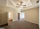 Spacious carpeted bedroom featuring a trey ceiling, ceiling fan, and ensuite bathroom at 710 Thomasville Se Blvd, Atlanta, GA 30315