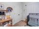 Bedroom with a black crib, wooden side table with decor, white doors, plush carpet and modern wall decor at 100 Chantilly Ln, Fayetteville, GA 30215