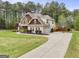 Expansive lawn and long driveway leading to a charming home with basketball hoop for outdoor enjoyment at 100 Chantilly Ln, Fayetteville, GA 30215