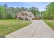 Long driveway leads to a charming home, complimented by a lush lawn and basketball hoop at 100 Chantilly Ln, Fayetteville, GA 30215