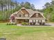 Charming two-story home featuring stone and shingle accents, manicured landscaping, and an inviting walkway at 100 Chantilly Ln, Fayetteville, GA 30215