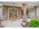 Inviting front porch featuring stone accents, a cozy swing, and decorative wreaths on the double doors at 100 Chantilly Ln, Fayetteville, GA 30215