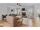 Open concept living room with stone fireplace, hardwood floors and ceiling fan at 100 Chantilly Ln, Fayetteville, GA 30215