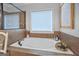 Relaxing soaking tub with tile surround, a window for natural light, and decorative elements for a spa-like feel at 100 Chantilly Ln, Fayetteville, GA 30215
