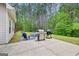 Outdoor patio featuring seating, barbecue grills, and a view of the expansive, treed backyard at 100 Chantilly Ln, Fayetteville, GA 30215