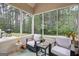 Relaxing screened porch with outdoor seating to enjoy views of the serene wooded backyard at 100 Chantilly Ln, Fayetteville, GA 30215