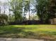 Backyard featuring mature trees, green grass and a wooden fence at 1611 Cherry Hill Sw Ct, Conyers, GA 30094