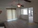 Open living room with vinyl floors, fan, and view into an adjacent kitchen space at 1611 Cherry Hill Sw Ct, Conyers, GA 30094
