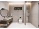Modern bathroom with double vanity, glass shower, and neutral stone tile at 2700 Antioch Ne St, Conyers, GA 30013