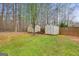 Backyard showcasing the two storage sheds, lawn mower and mature trees at 240 Sturgess Run, Sharpsburg, GA 30277