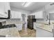 Bright kitchen features stainless steel appliances, white cabinets, and granite countertops at 240 Sturgess Run, Sharpsburg, GA 30277