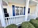 Inviting front porch featuring a white railing and a window with blue shutters and manicured landscaping at 3353 Medina Dr, Jonesboro, GA 30236