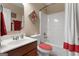 Well-lit bathroom with a stylish vanity, toilet with red seat cover, and shower-tub combo at 409 Brandy Ln, Mcdonough, GA 30253
