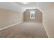 Large bonus room with neutral carpet and walls, featuring a single window at 409 Brandy Ln, Mcdonough, GA 30253