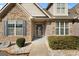 Inviting front entryway showcasing a stone exterior, decorative shrubs, and a covered porch at 409 Brandy Ln, Mcdonough, GA 30253