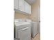 Functional laundry room with white appliances and ample storage cabinets at 409 Brandy Ln, Mcdonough, GA 30253