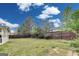 Large backyard with grass, fencing, and mature trees on a sunny day at 540 Hamlet Dr, Hampton, GA 30228