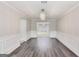 Dining room featuring hardwood floors, wainscoting, modern lighting, and view of living room at 540 Hamlet Dr, Hampton, GA 30228