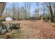 Leaf covered backyard with patio set, trampoline and play area at 1103 Larkspur Dr, Locust Grove, GA 30248