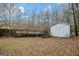 A spacious backyard featuring a wooden deck, shed, and beautiful tree coverage at 1103 Larkspur Dr, Locust Grove, GA 30248